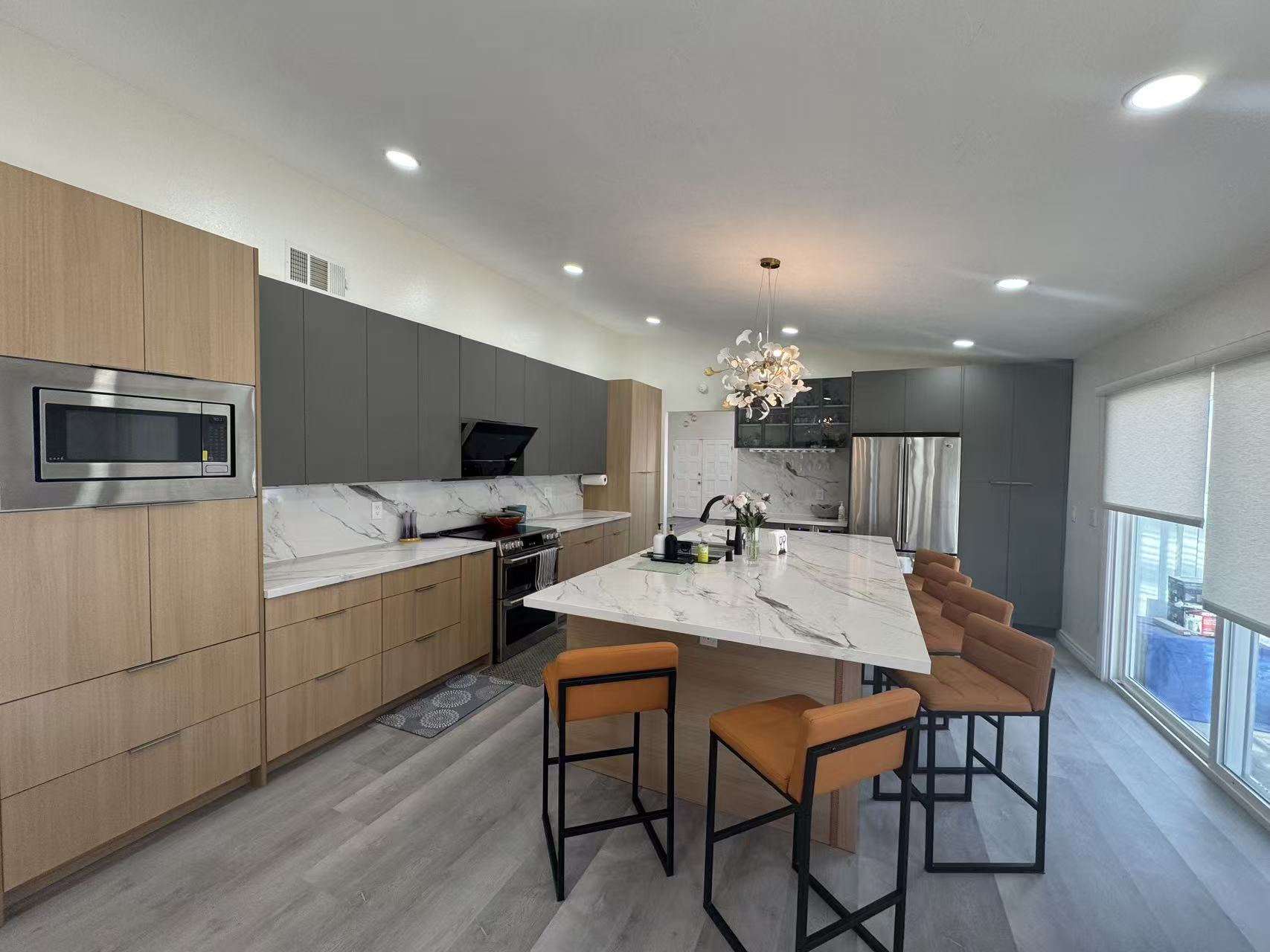 Kitchen after remodel with island, cabinetry, counters, and lighting at Shuyi House Miramesa