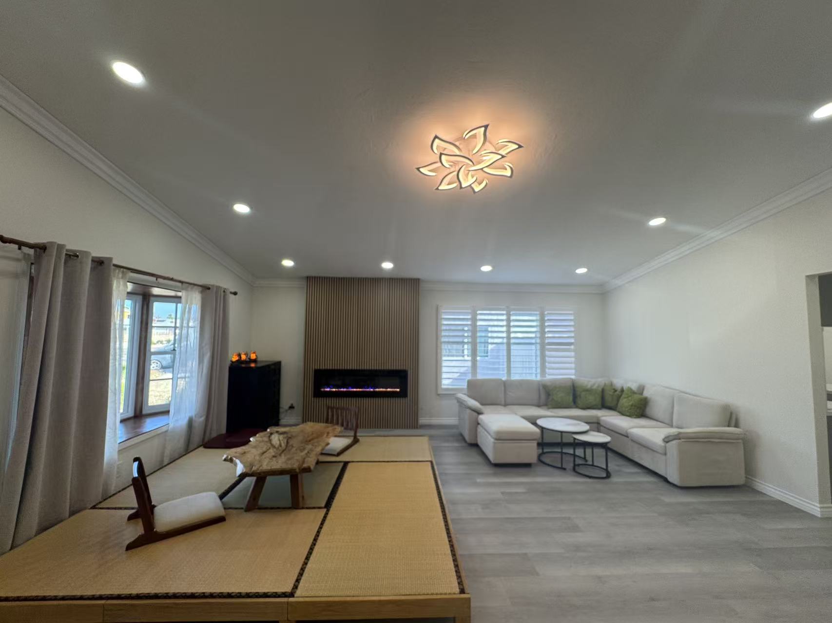 Living room after remodel with fireplace wall, recessed lighting, and seating at Shuyi House Miramesa