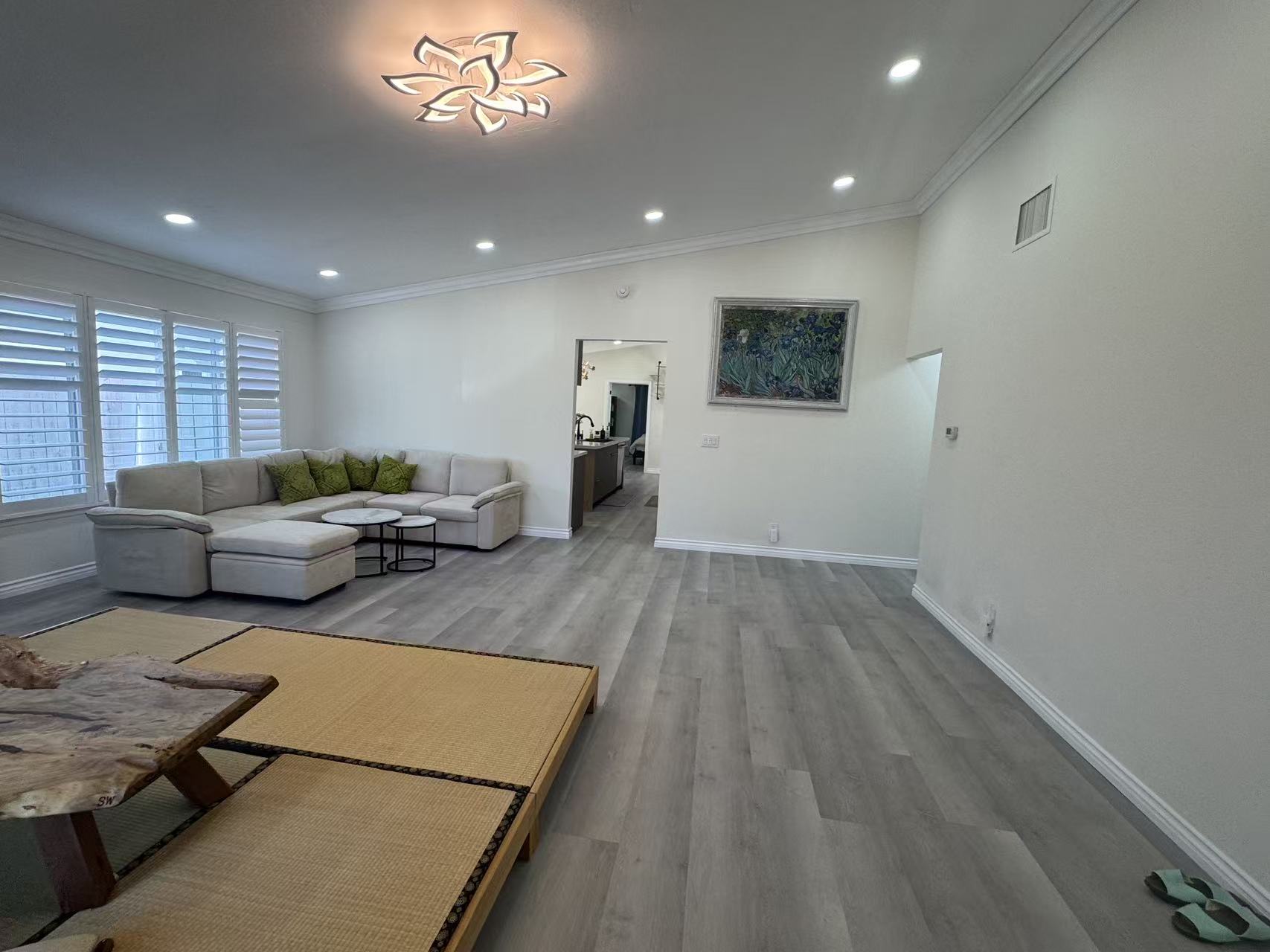 Living room after remodel with bright flooring, lighting, and neutral wall finish at Shuyi House Miramesa